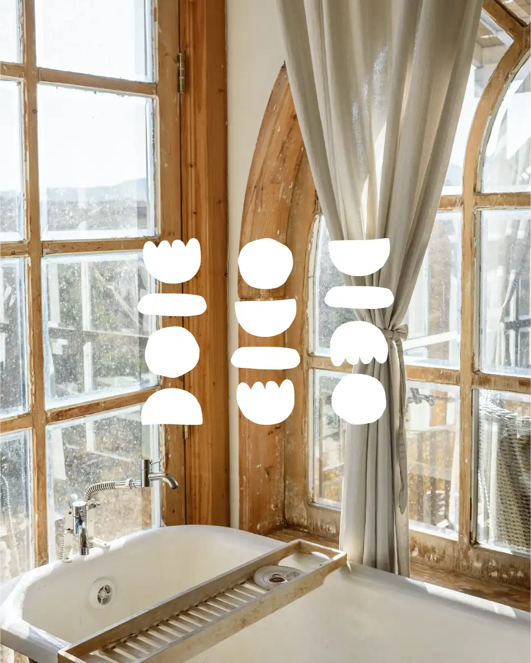 Logotype de l'identité visuelle de Marina Trillot, par le Studio La Juria, en blanc sur un fond photo d'un intérieur de salle de bain, avec une baignoire en bas entourée de grandes fenêtres à carreaux entourés de cadres de bois clair.
