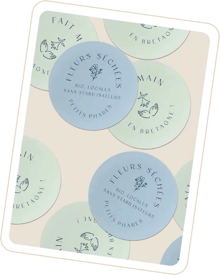 Des stickers de couleurs bleu et bleu-vert pour la marque Petits Phares, avec des labels aux textes "fleurs séchées bio, locales, sans stabilisateurs" ou "fait main en Bretagne".